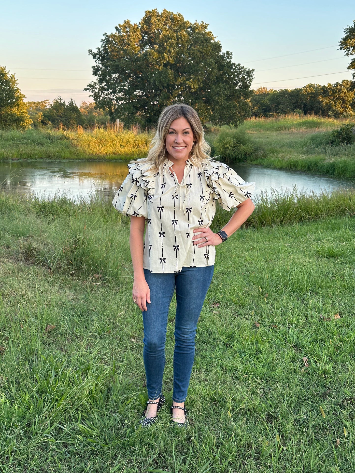 Bow print short puff sleeve v-neck top w/ tiered scallop delay at shoulders. Ruffle neckline