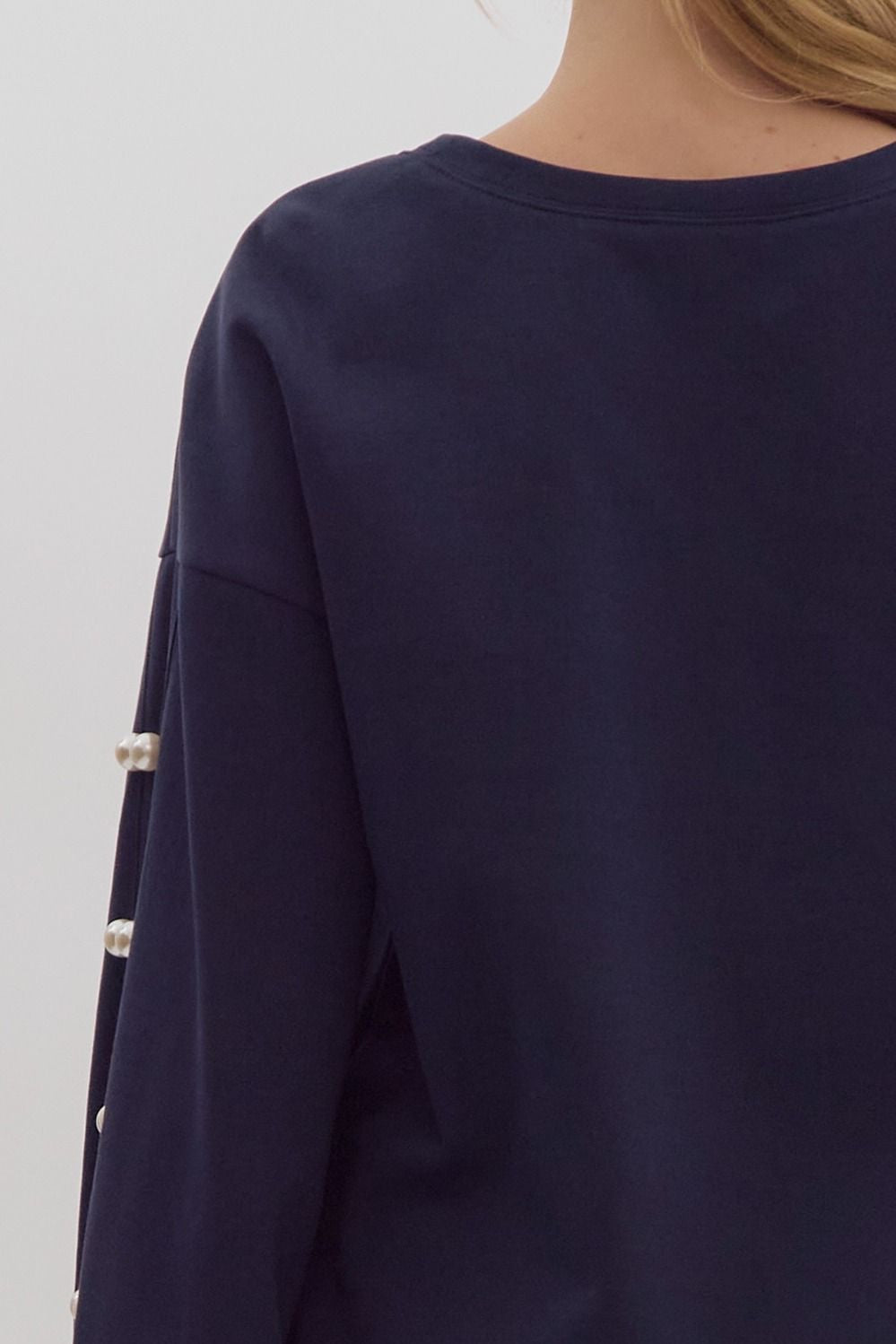 Solid long sleeve round neck sweater mini dress w/ pockets. Pearl embellishments at sleeves