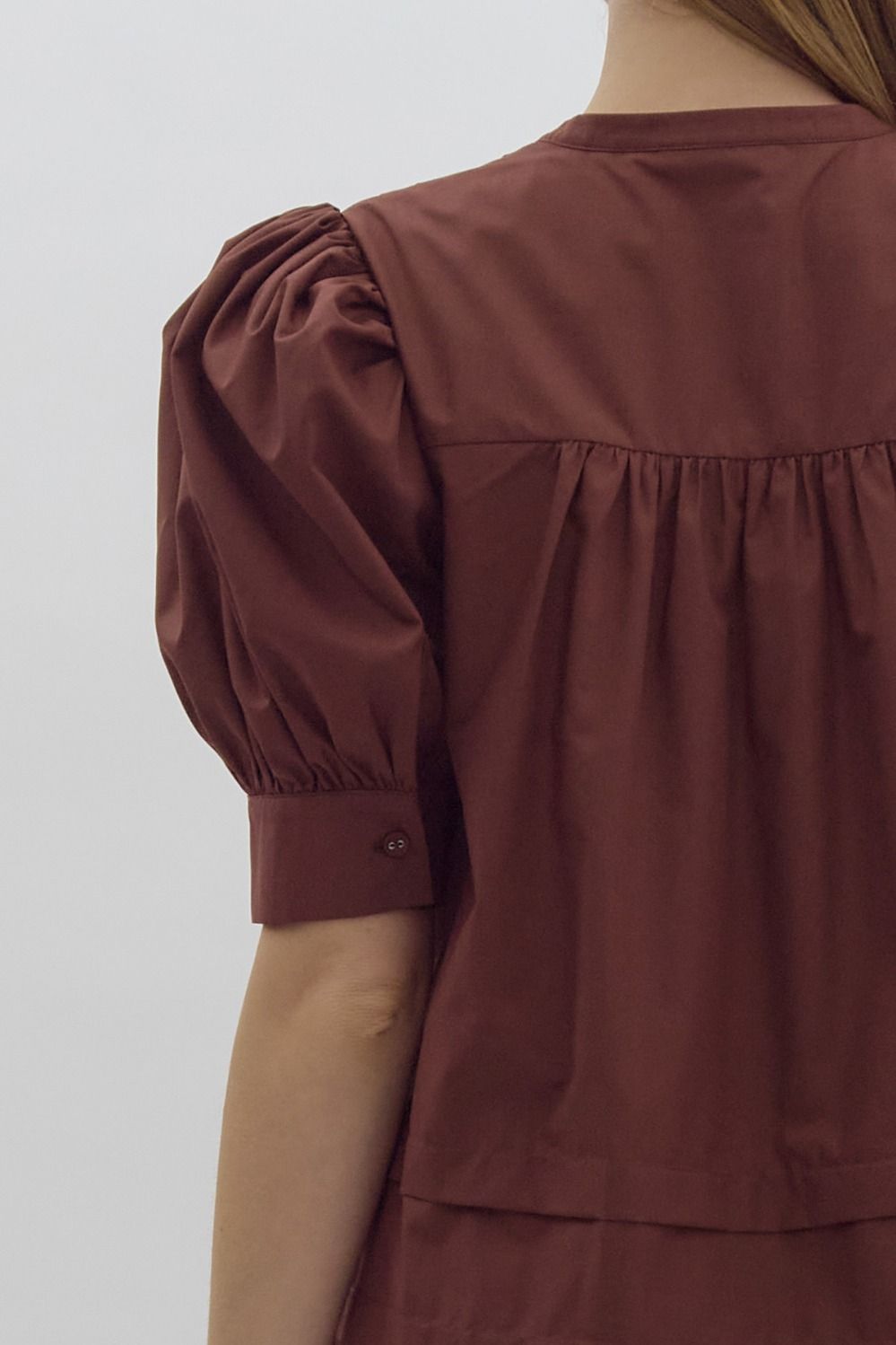 Solid pin tucked short sleeve mini dress w/ pockets, puff sleeves, & button detail at bust