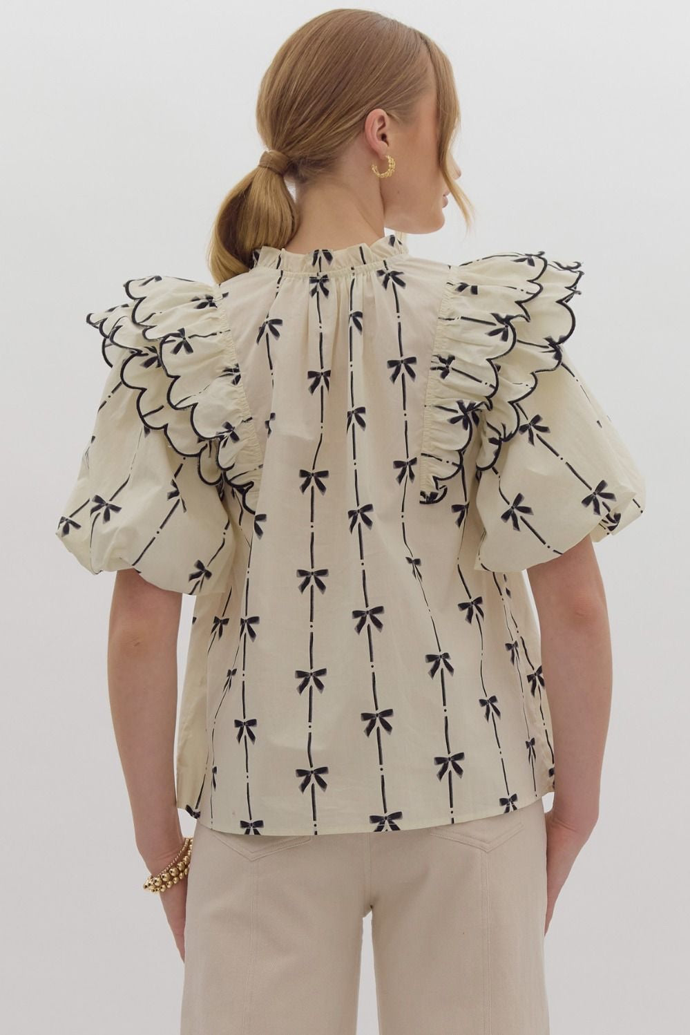 Bow print short puff sleeve v-neck top w/ tiered scallop delay at shoulders. Ruffle neckline