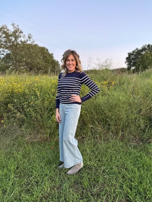Navy stripe print long sleeve round neck top w/ button up detail at cuff.
