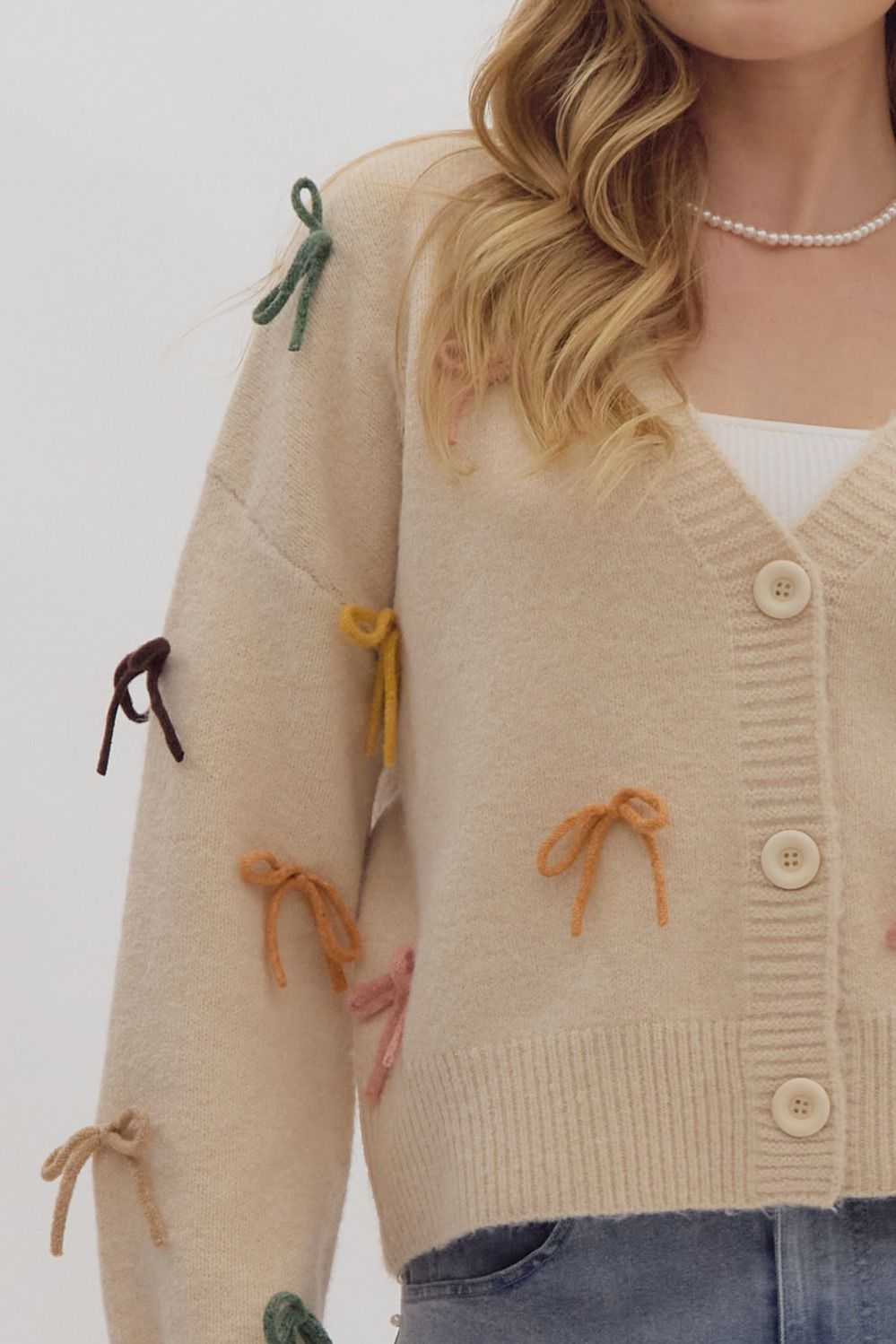 Solid long sleeve button down cropped cardigan w/ multi color bow appliqués