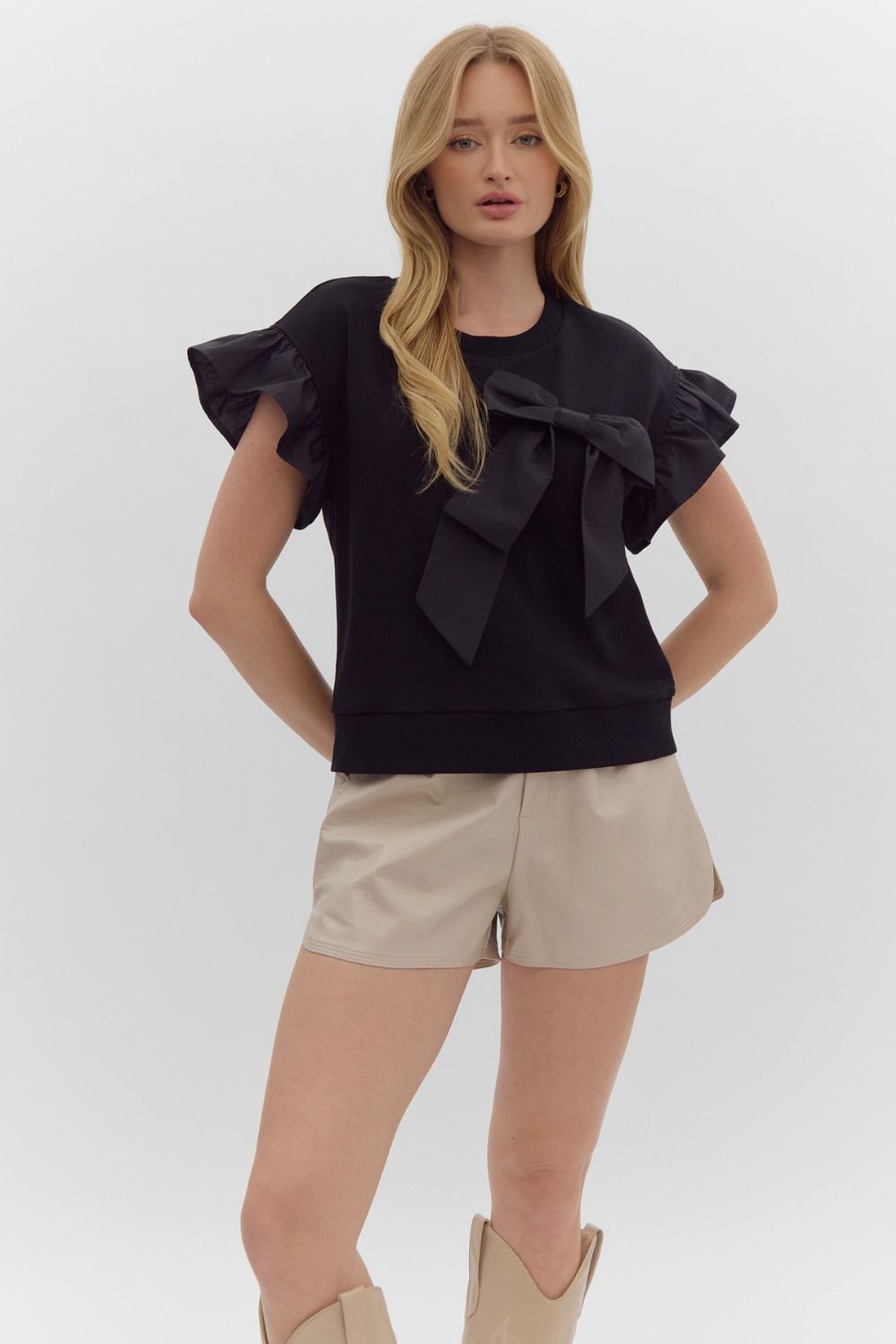 Solid short sleeve round neck top w/ ruffled sleeves. Ribbon detail @ bust.