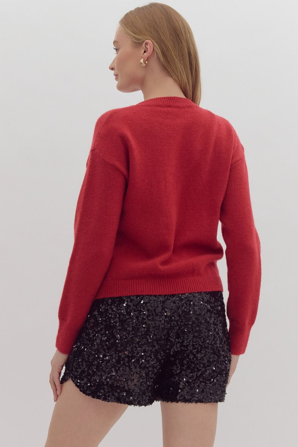Solid long sleeved sweater knit pullover w/ over sized sequin bow at front