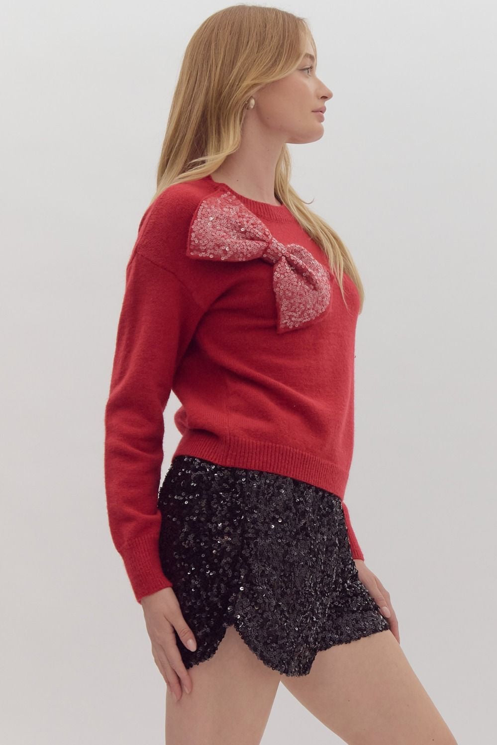 Solid long sleeved sweater knit pullover w/ over sized sequin bow at front