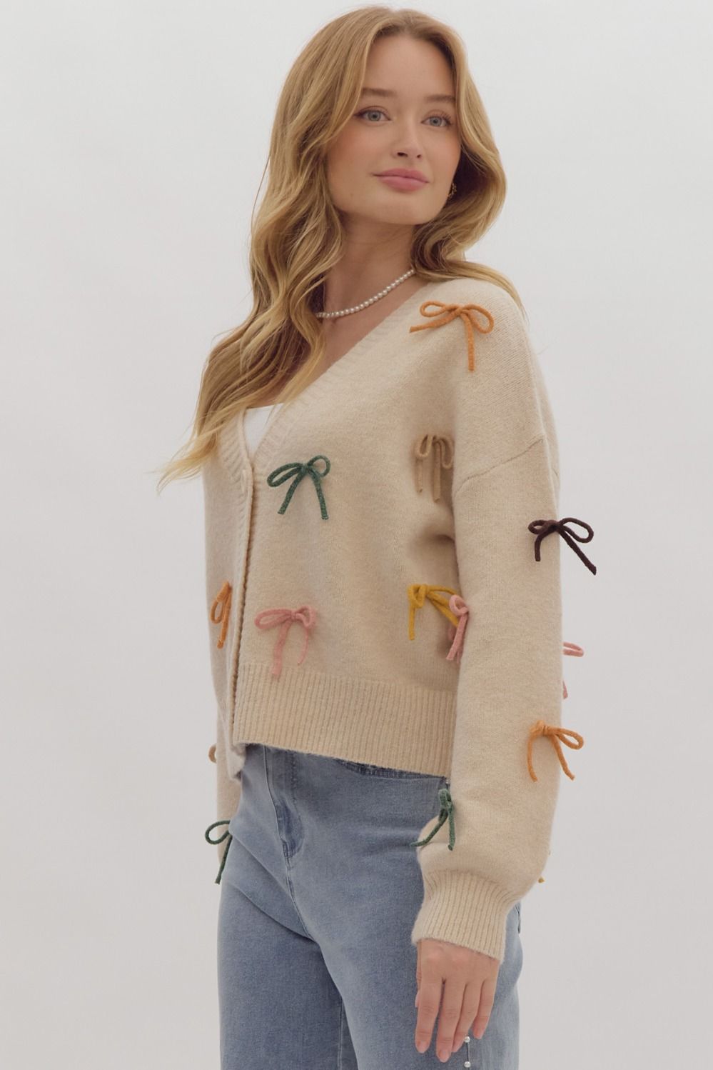 Solid long sleeve button down cropped cardigan w/ multi color bow appliqués
