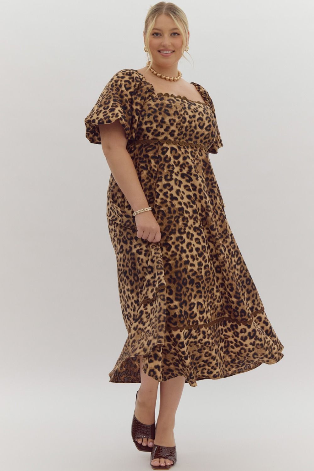 Cheetah print square neck bubble sleeve midi dress w/ ric rac trim. Elastic at cuff. Smocking at back. Pockets.