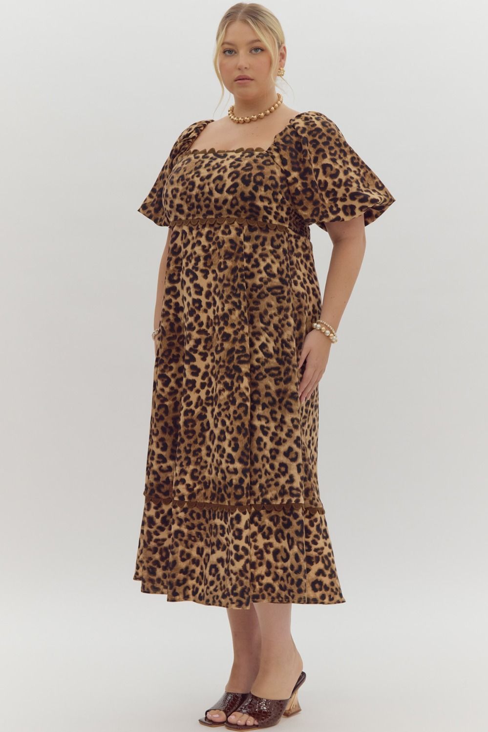 Cheetah print square neck bubble sleeve midi dress w/ ric rac trim. Elastic at cuff. Smocking at back. Pockets.