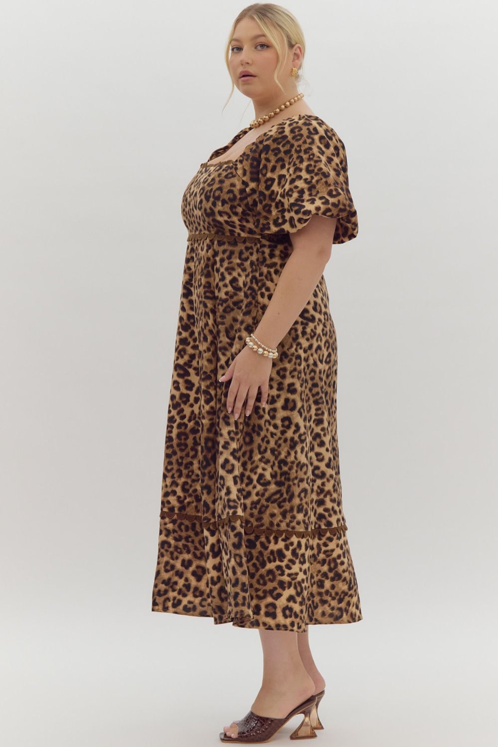 Cheetah print square neck bubble sleeve midi dress w/ ric rac trim. Elastic at cuff. Smocking at back. Pockets.
