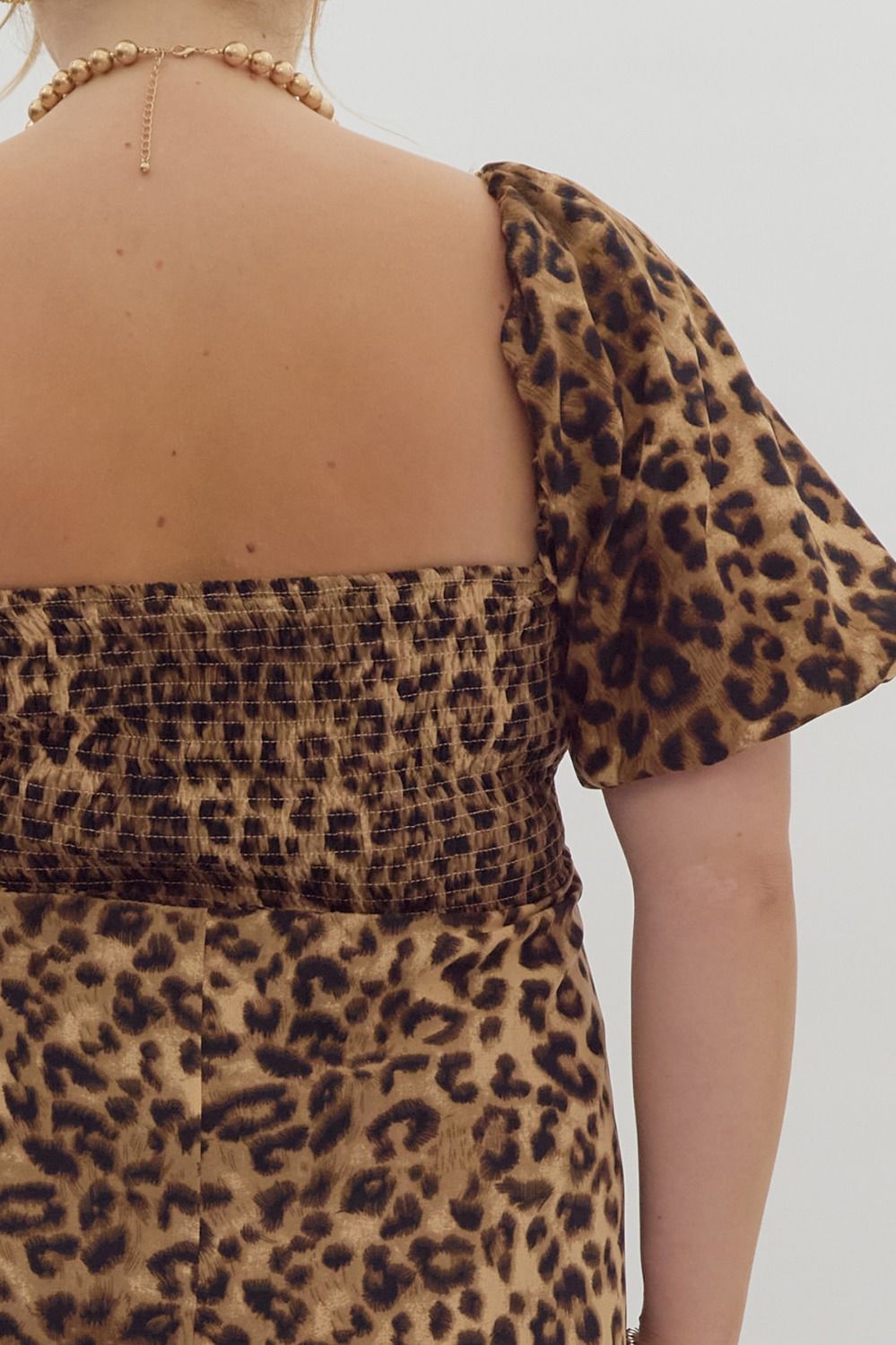 Cheetah print square neck bubble sleeve midi dress w/ ric rac trim. Elastic at cuff. Smocking at back. Pockets.