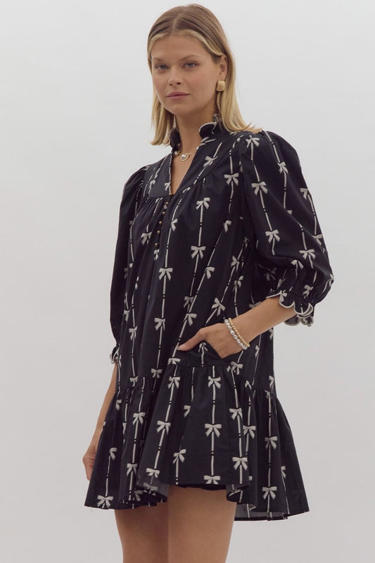 Bow print 3/4 sleeve v neck mini dress w/ button up detail at bust. Ruffled detail at cuff & neckline pockets