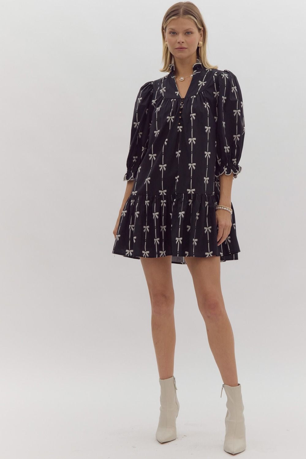 Bow print 3/4 sleeve v neck mini dress w/ button up detail at bust. Ruffled detail at cuff & neckline pockets