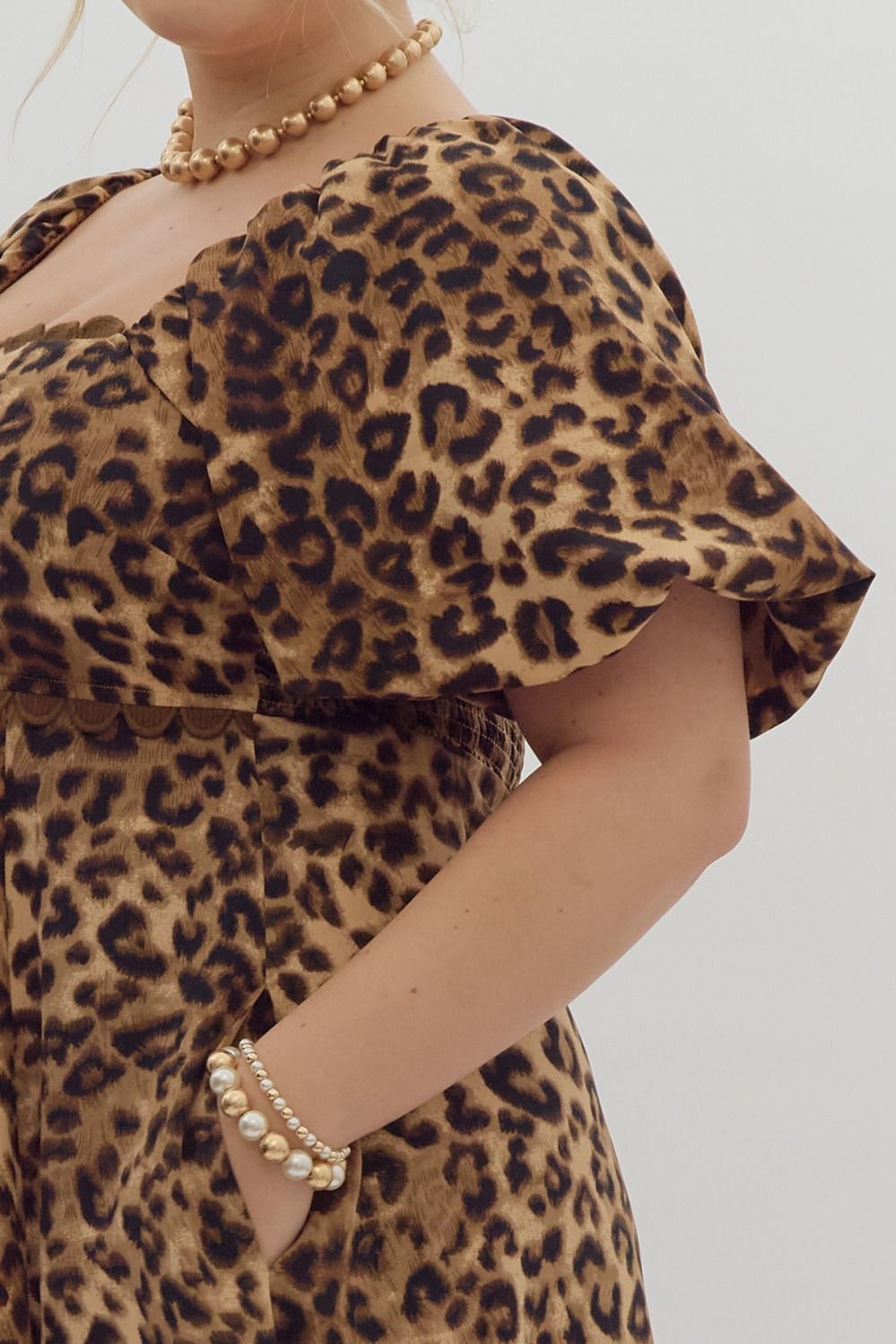 Cheetah print square neck bubble sleeve midi dress w/ ric rac trim. Elastic at cuff. Smocking at back. Pockets.