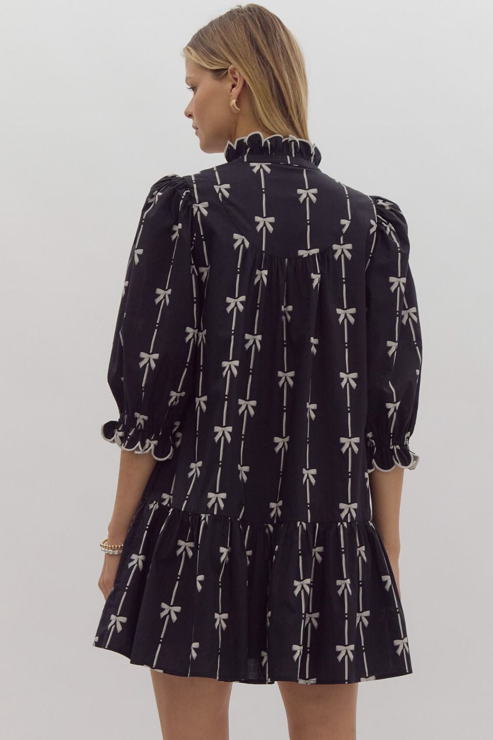 Bow print 3/4 sleeve v neck mini dress w/ button up detail at bust. Ruffled detail at cuff & neckline pockets