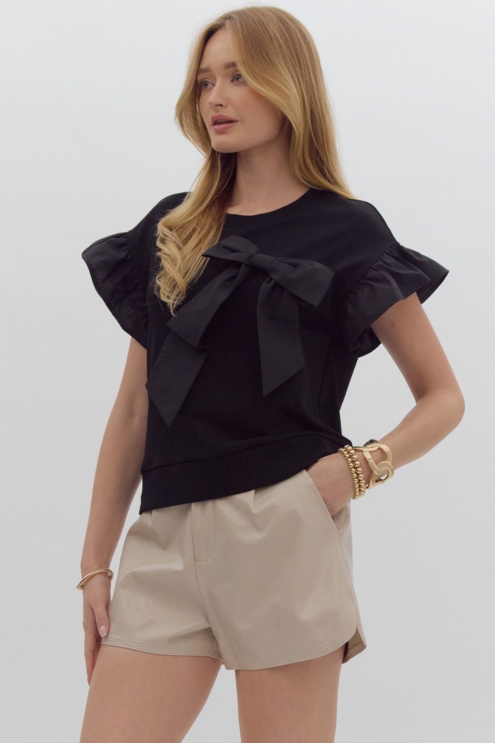 Solid short sleeve round neck top w/ ruffled sleeves. Ribbon detail @ bust.