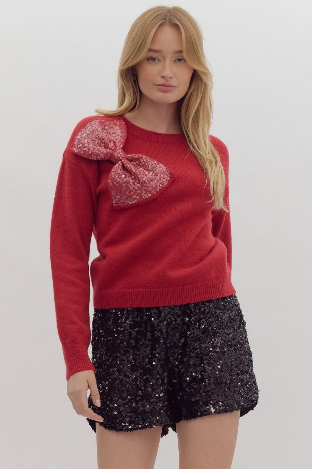 Solid long sleeved sweater knit pullover w/ over sized sequin bow at front