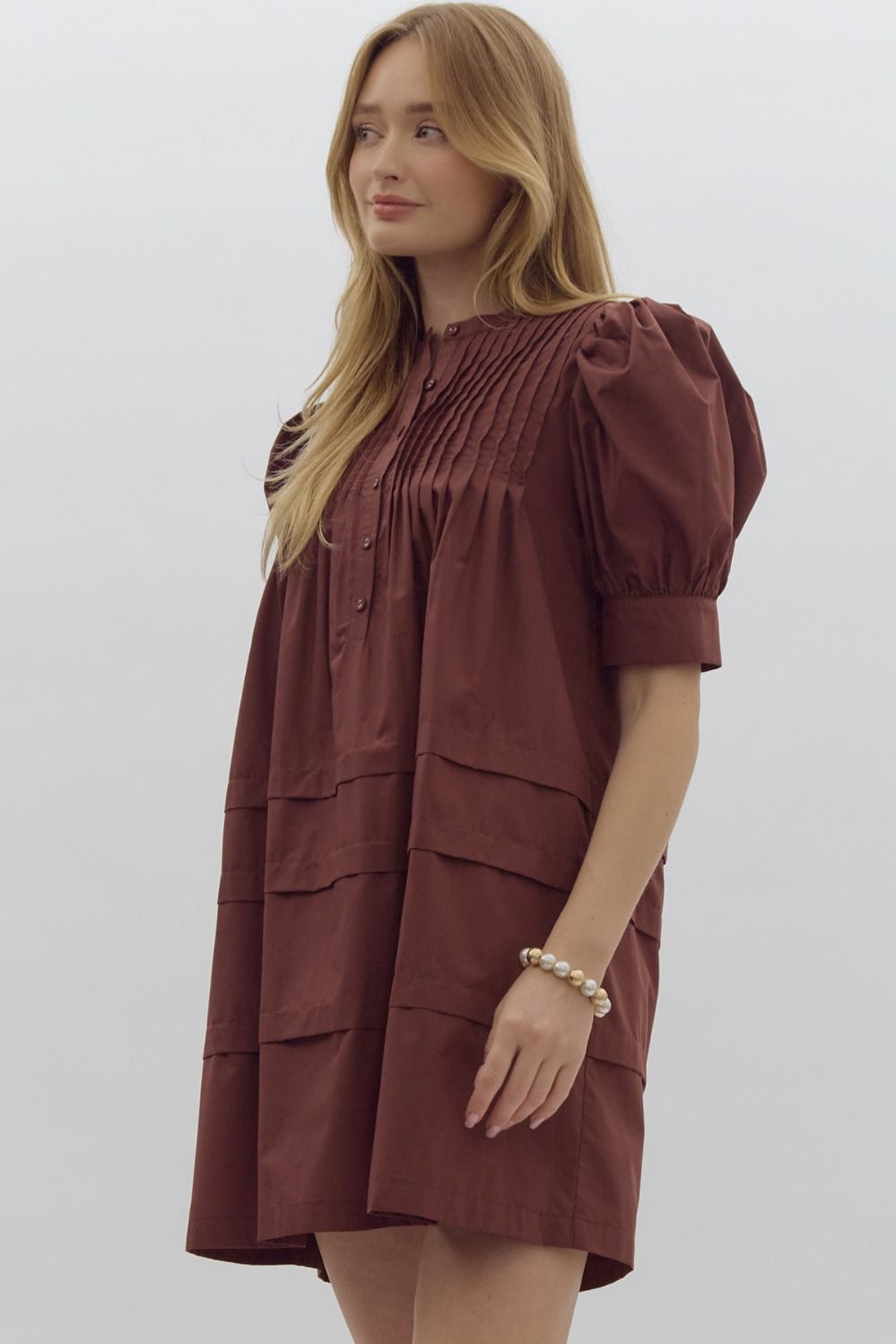 Solid pin tucked short sleeve mini dress w/ pockets, puff sleeves, & button detail at bust