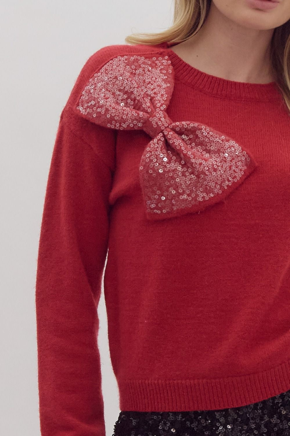 Solid long sleeved sweater knit pullover w/ over sized sequin bow at front