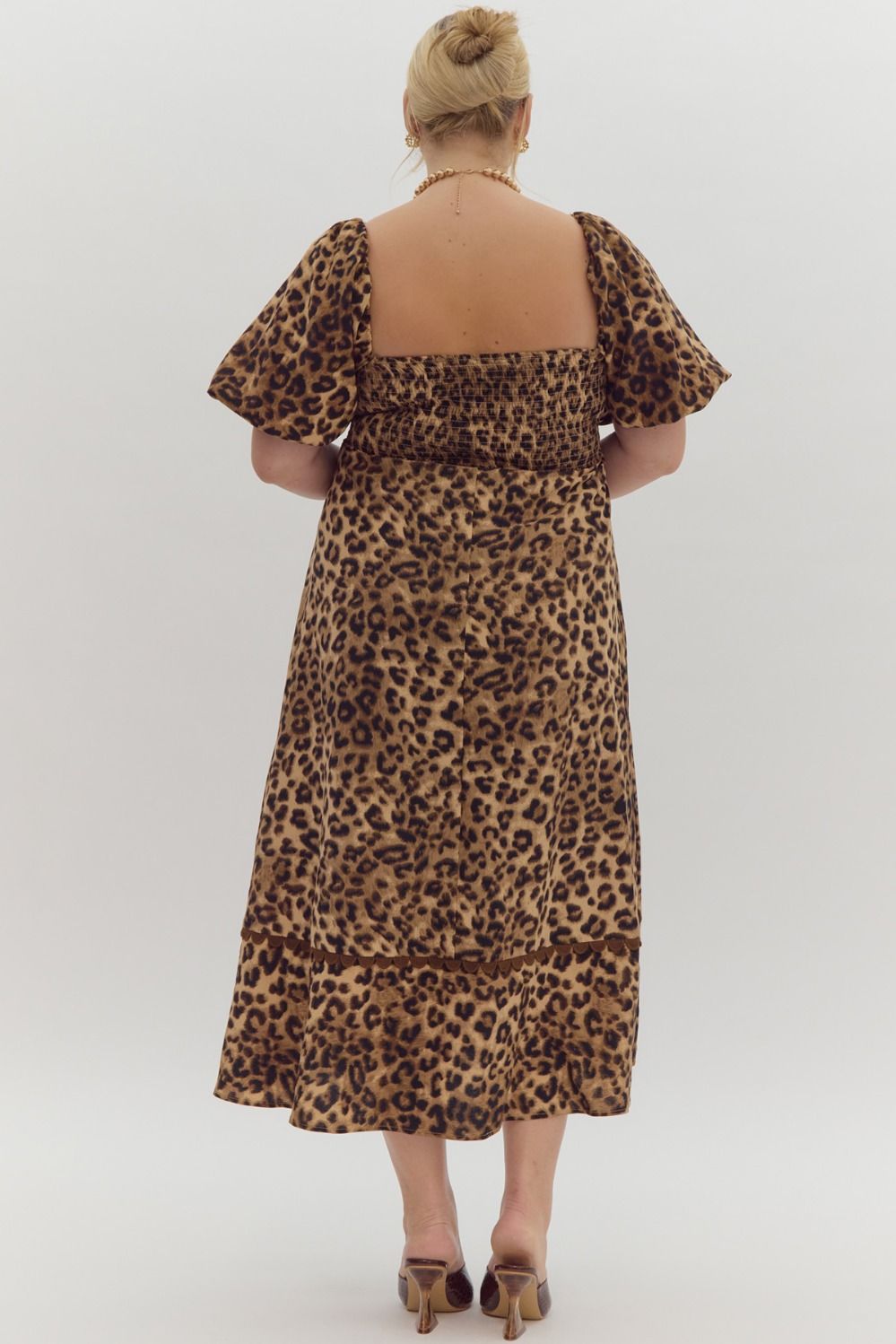 Cheetah print square neck bubble sleeve midi dress w/ ric rac trim. Elastic at cuff. Smocking at back. Pockets.