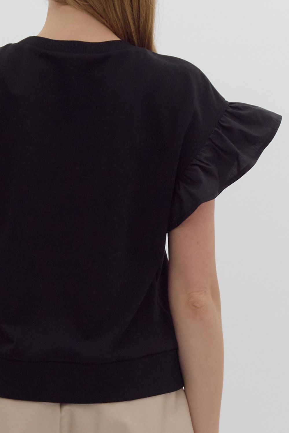 Solid short sleeve round neck top w/ ruffled sleeves. Ribbon detail @ bust.