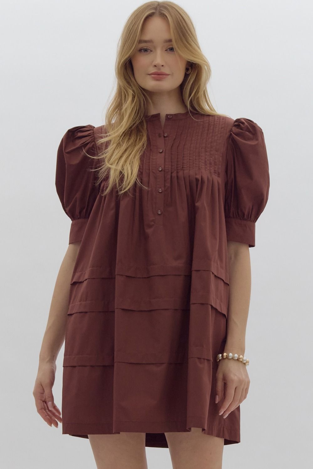 Solid pin tucked short sleeve mini dress w/ pockets, puff sleeves, & button detail at bust