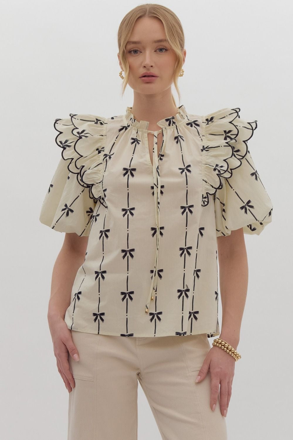 Bow print short puff sleeve v-neck top w/ tiered scallop delay at shoulders. Ruffle neckline