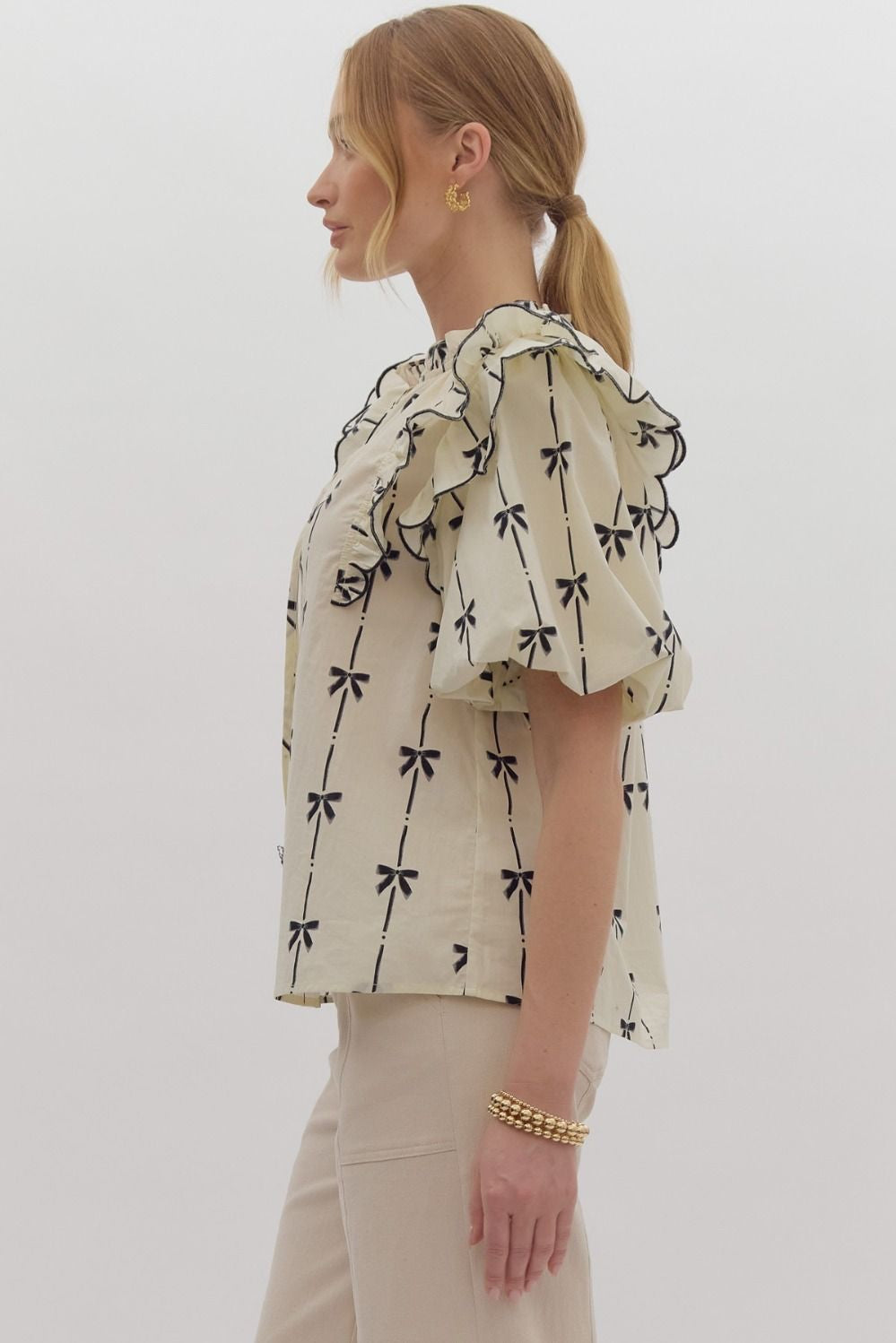 Bow print short puff sleeve v-neck top w/ tiered scallop delay at shoulders. Ruffle neckline