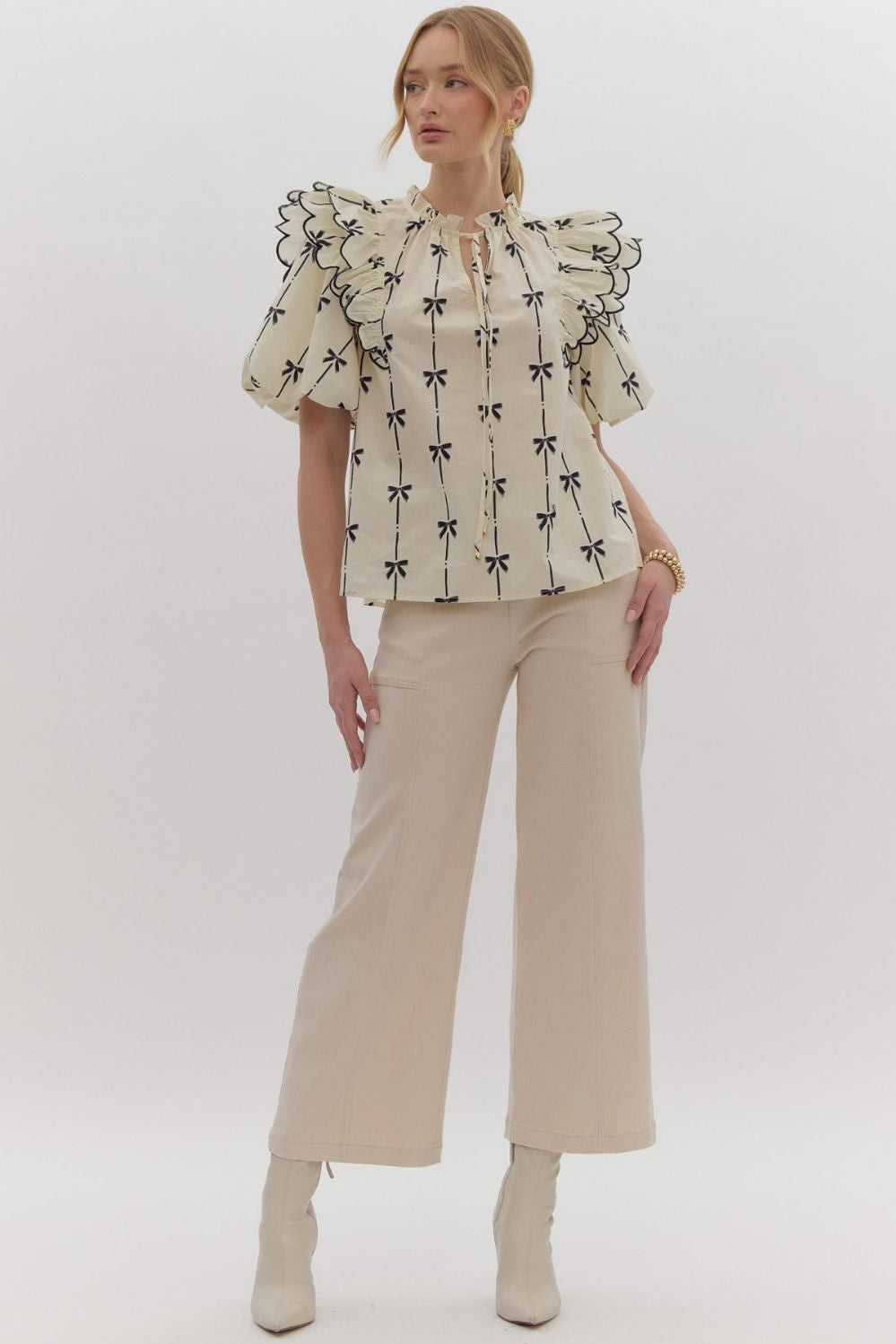 Bow print short puff sleeve v-neck top w/ tiered scallop delay at shoulders. Ruffle neckline