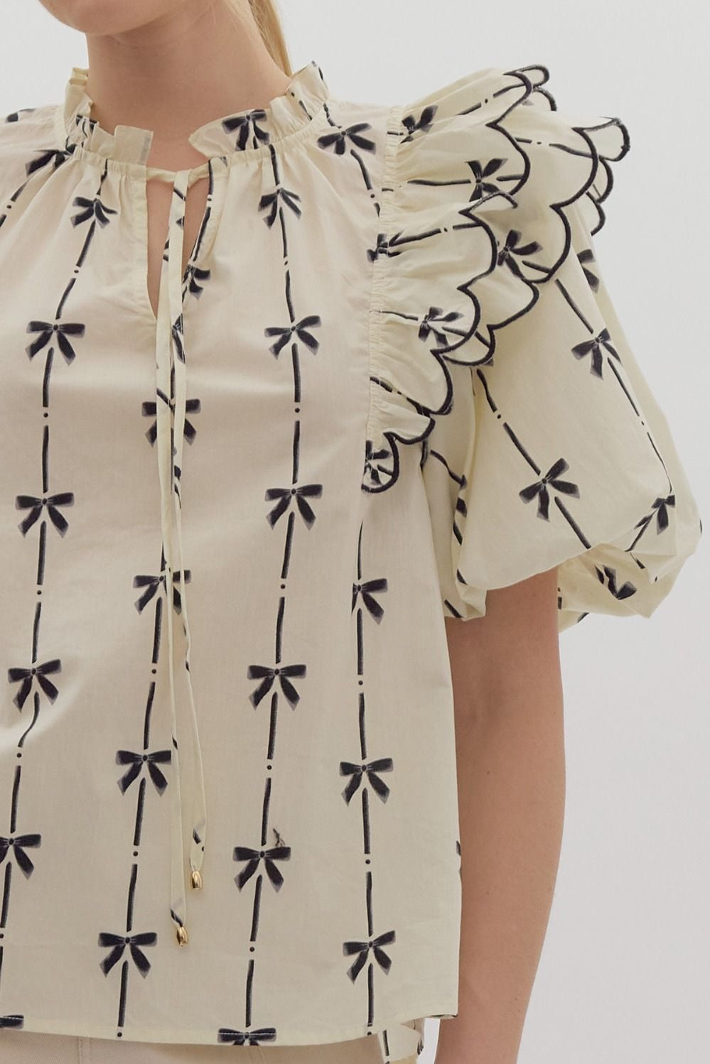 Bow print short puff sleeve v-neck top w/ tiered scallop delay at shoulders. Ruffle neckline