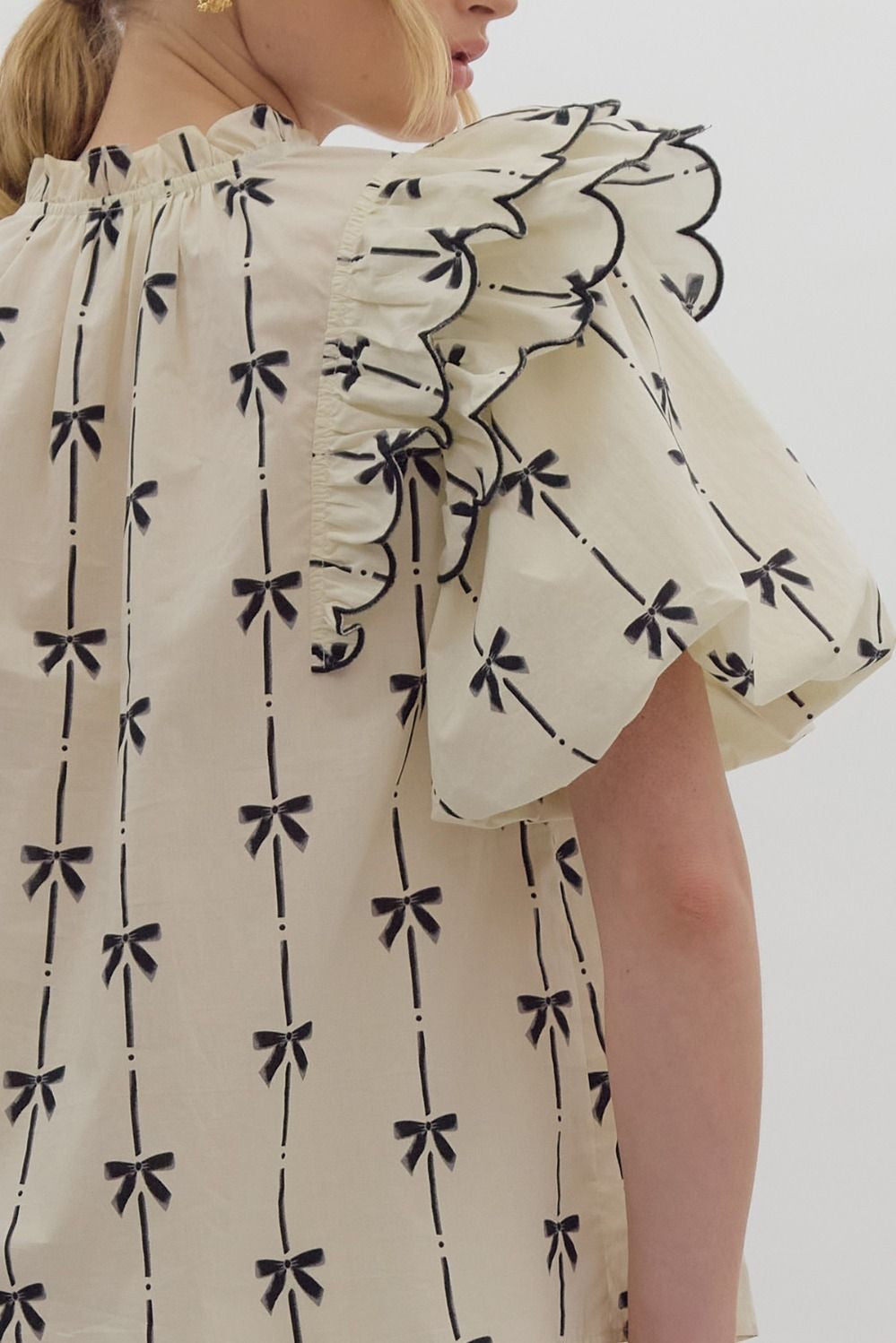 Bow print short puff sleeve v-neck top w/ tiered scallop delay at shoulders. Ruffle neckline